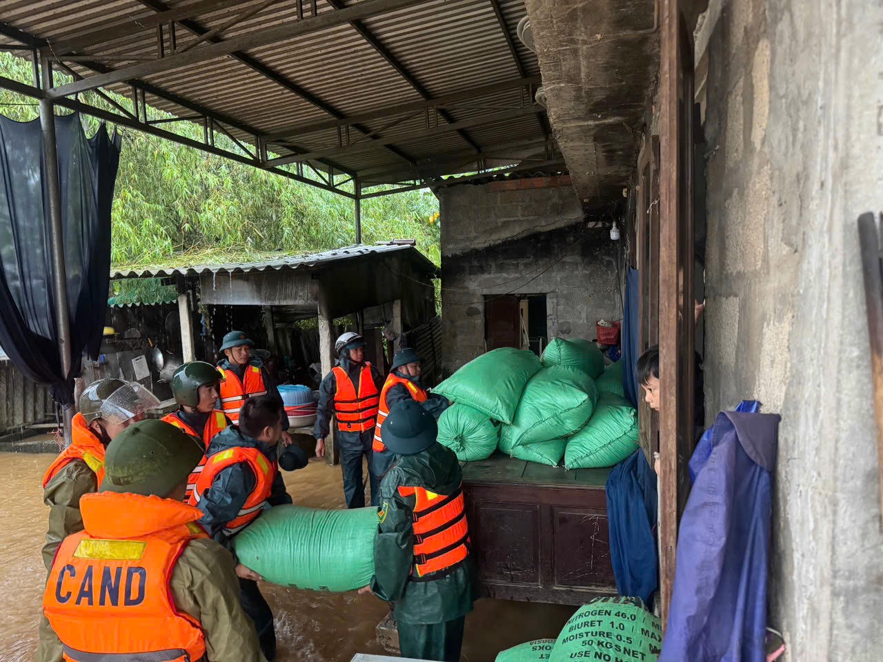 Cán bộ, chiến sĩ hỗ trợ người dân kê cao, di chuyển đồ đạc.