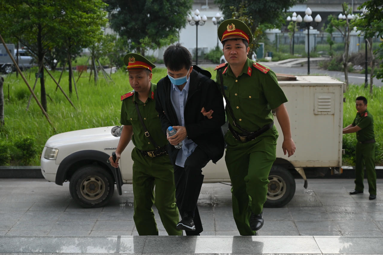 Dẫn giải bị cáo vào phòng xét xử.