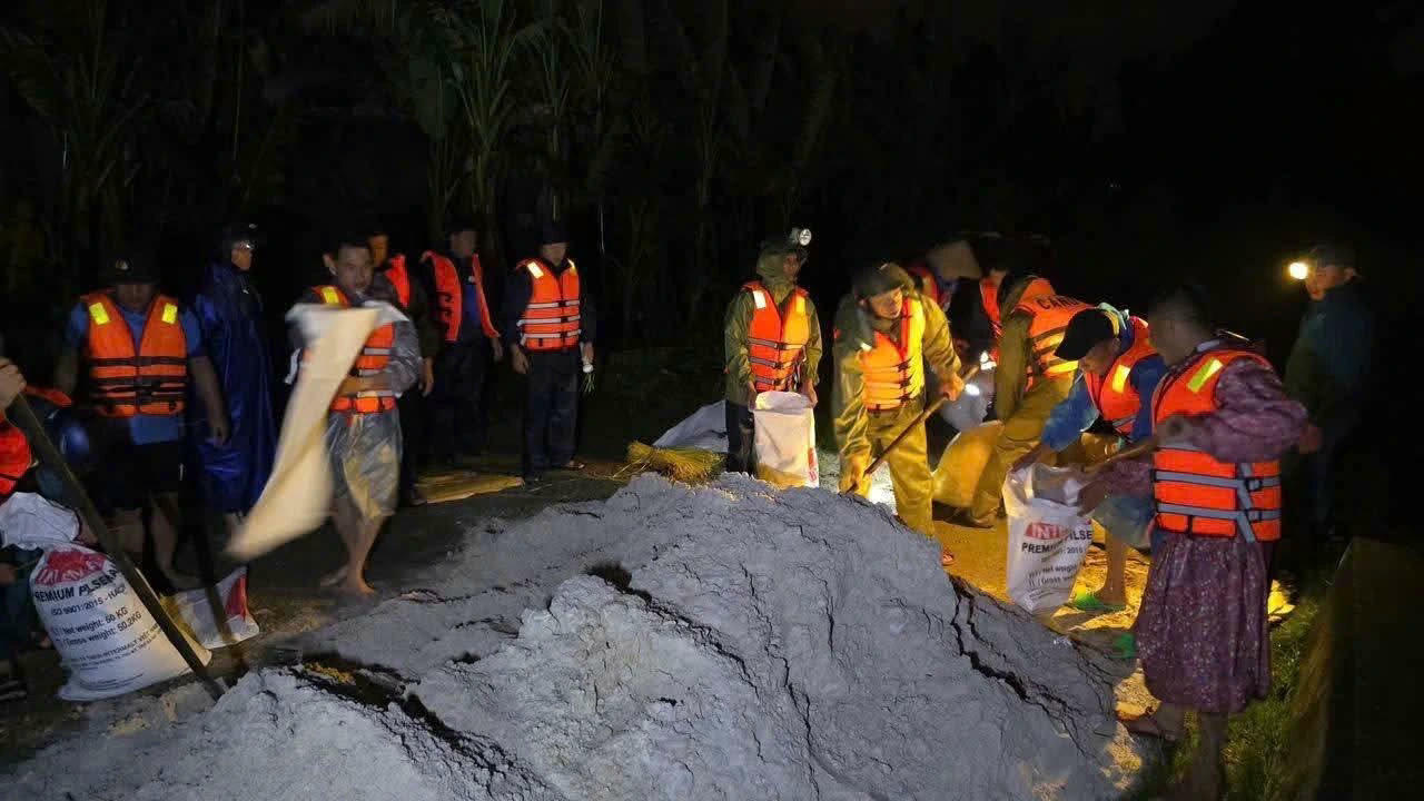 Cán bộ, chiến sĩ Lữ đoàn 574 vận chuyển bao cát gia cố đoạn đê bị vỡ trong mưa lớn.