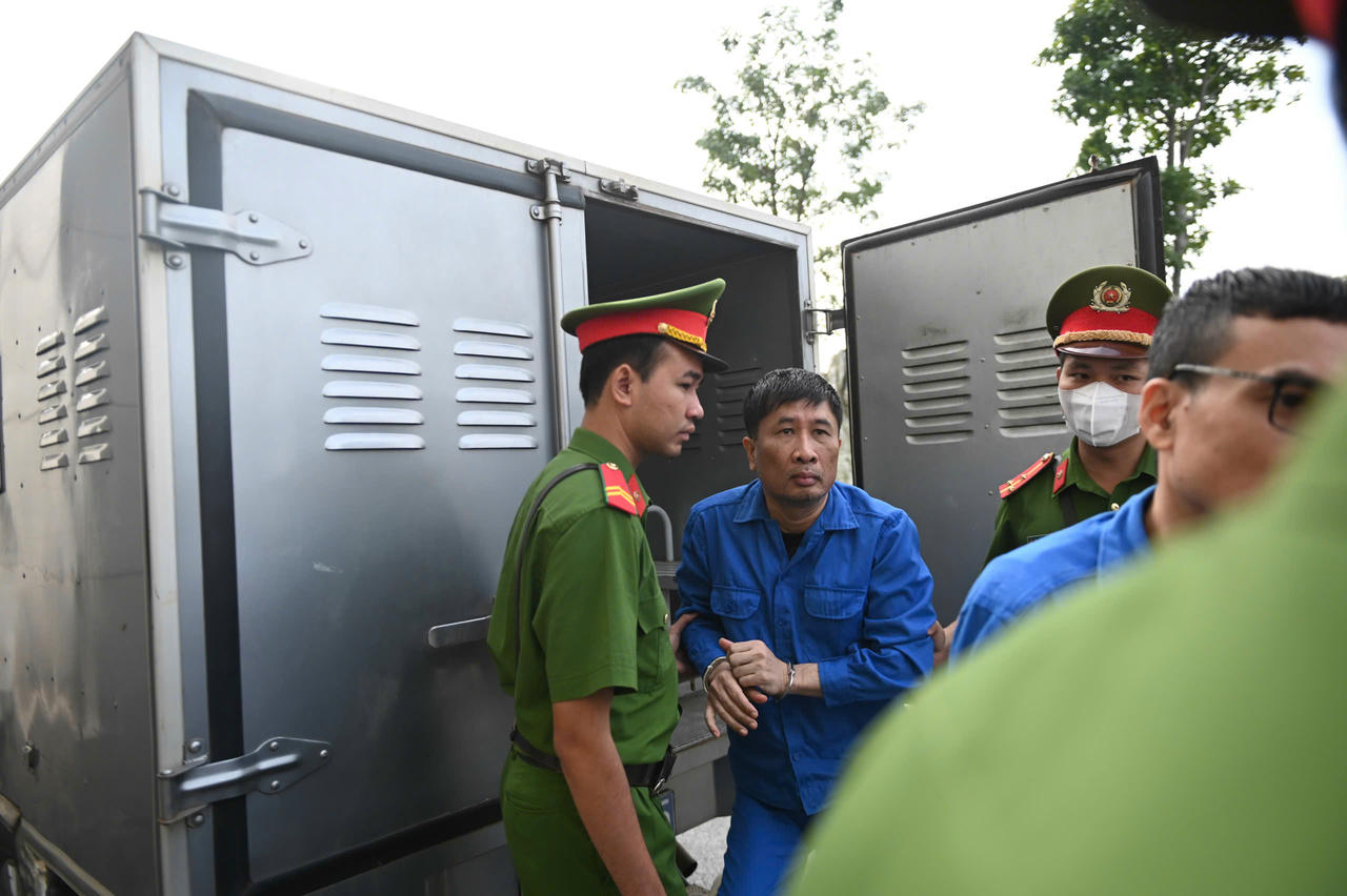 Dẫn giải bị cáo vào phòng xét xử.