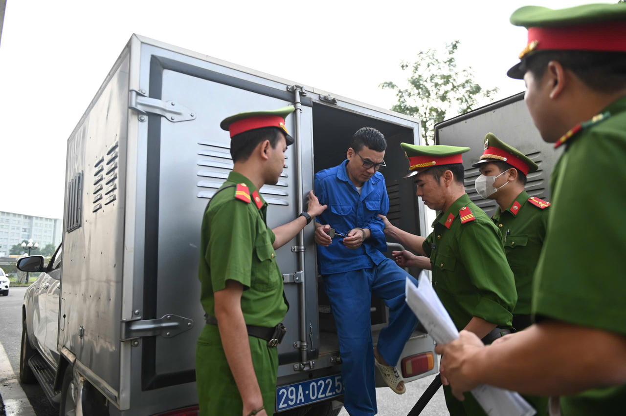 Dẫn giải bị cáo vào phòng xét xử.