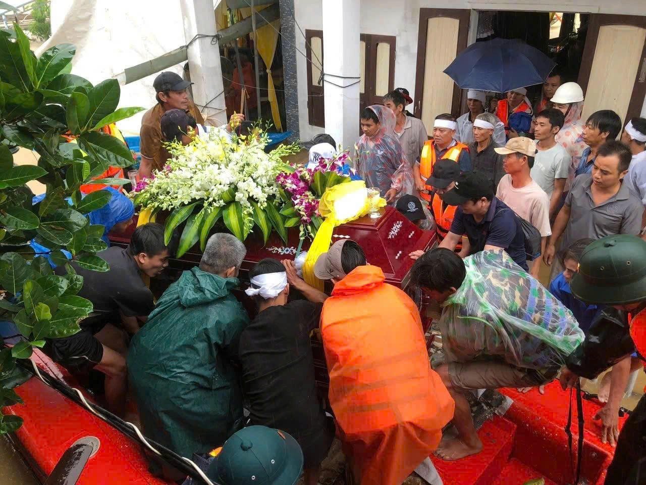 Lực lượng vũ trang TP Đà Nẵng hỗ trợ gia đình đưa quan tài cụ bà 106 tuổi vượt lũ đi an táng.