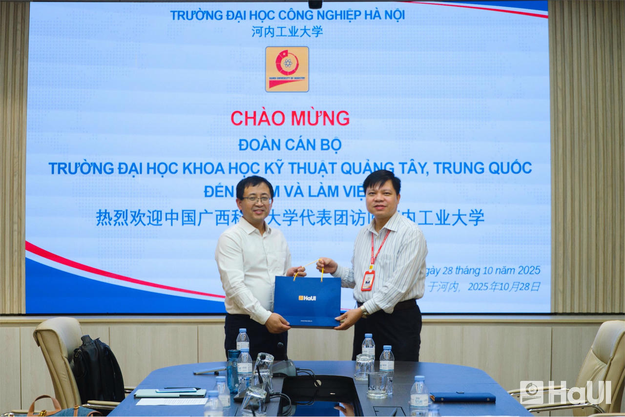 Ông Phạm Văn Đông - Phó Hiệu trưởng HaUI tặng quà lưu niệm cho ông Tôn Hậu Bình - Viện trưởng Viện Cơ khí và Ô tô, GXUST