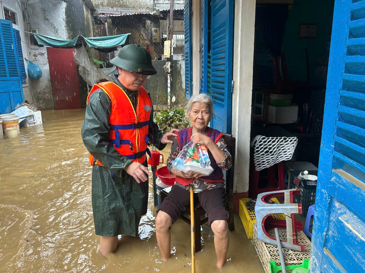 Ông Hạnh vừa phát cơm, vừa ân cần động viên, hỏi thăm bà con vùng lũ