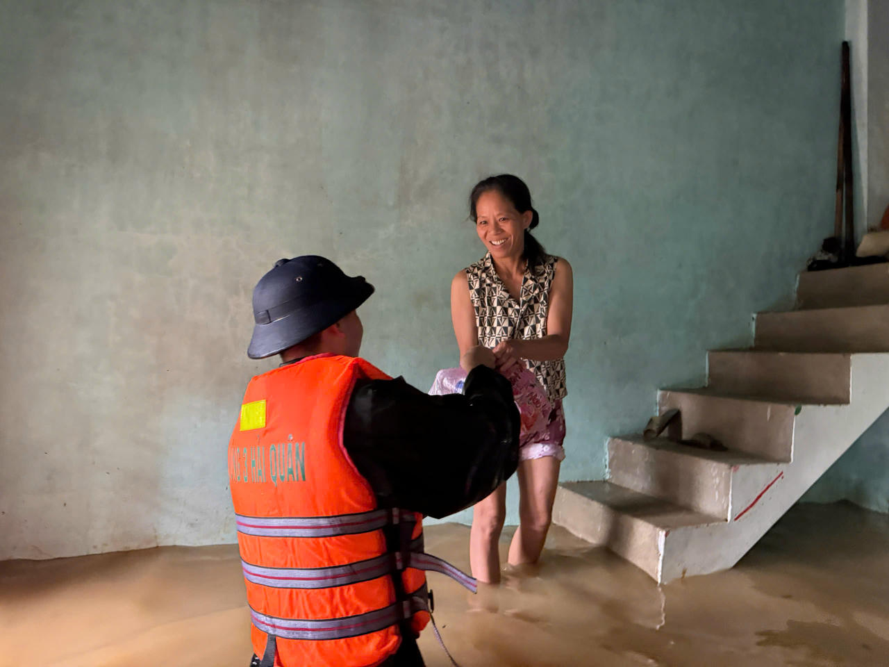 Lực lượng cứu trợ đưa nhu yếu phẩm, bàn giao cho tổ trưởng tổ dân phố tiếp tục đưa đến từng hộ gia đình bị ngập