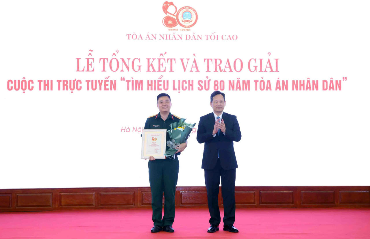 Phó Chánh án Tòa án nhân dân tối cao Nguyễn Văn Tiến trao giải Nhất cho thí sinh Đặng Anh Tú.