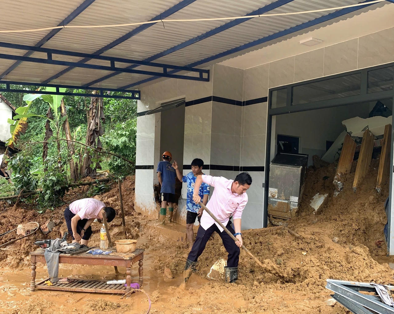 Cán bộ NHCSXH Quảng Ngãi chung tay cùng người dân khắc phục hậu quả mưa lũ.