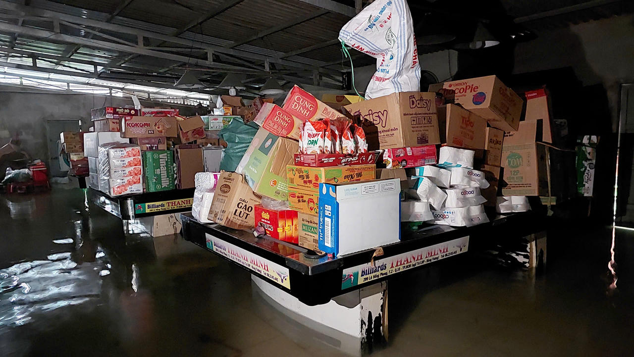 Người dân kê cao hàng hóa tránh lụt.