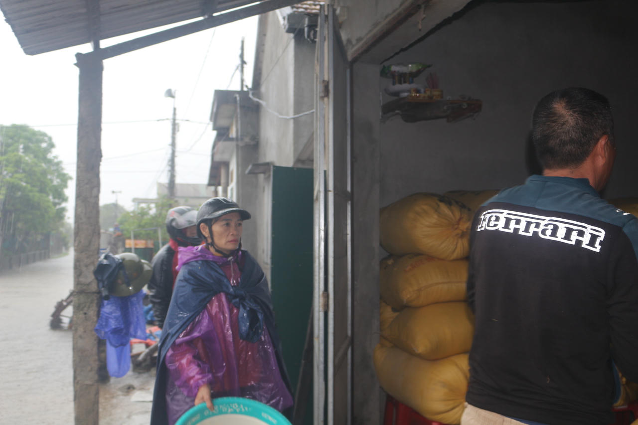 Nước lên nhanh, bà con chòm xóm sang hỗ trợ ông Ngà bốc lúa lên chỗ cao.