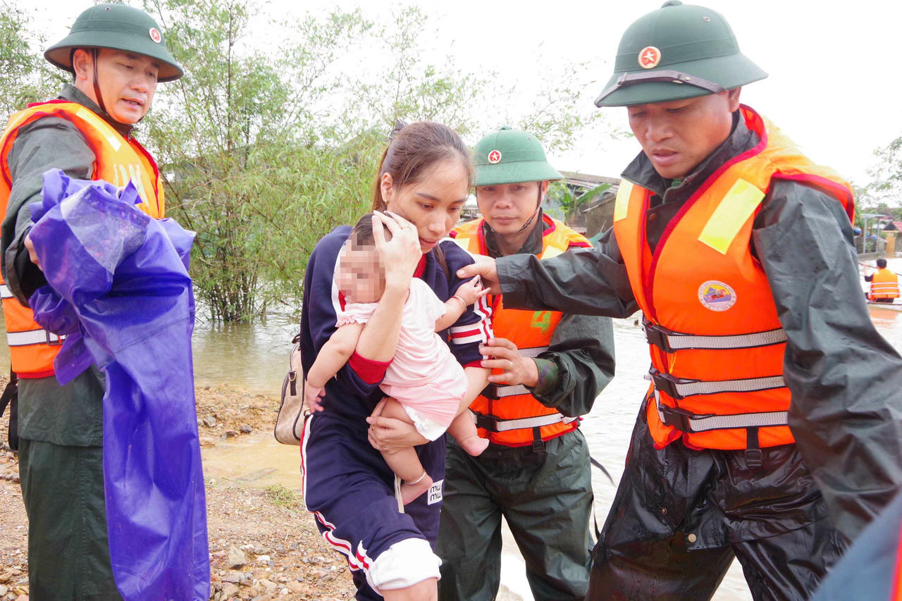 Các chiến sĩ Bộ Chỉ huy Quân sự tỉnh Hà Tĩnh hỗ trợ sơ tán người dân bị ngập lũ.