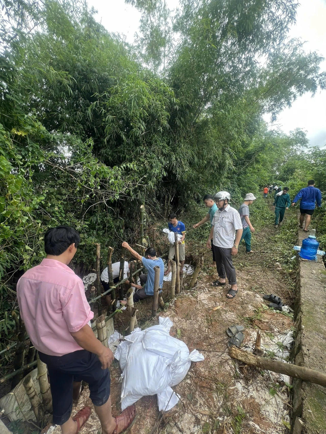 Hàng trăm người dân và các lực lượng tại chỗ của xã Tuy Phước Bắc "chạy đua" với thời gian, vận chuyển vật tư đến điểm đê xung yếu đang bị rò rỉ