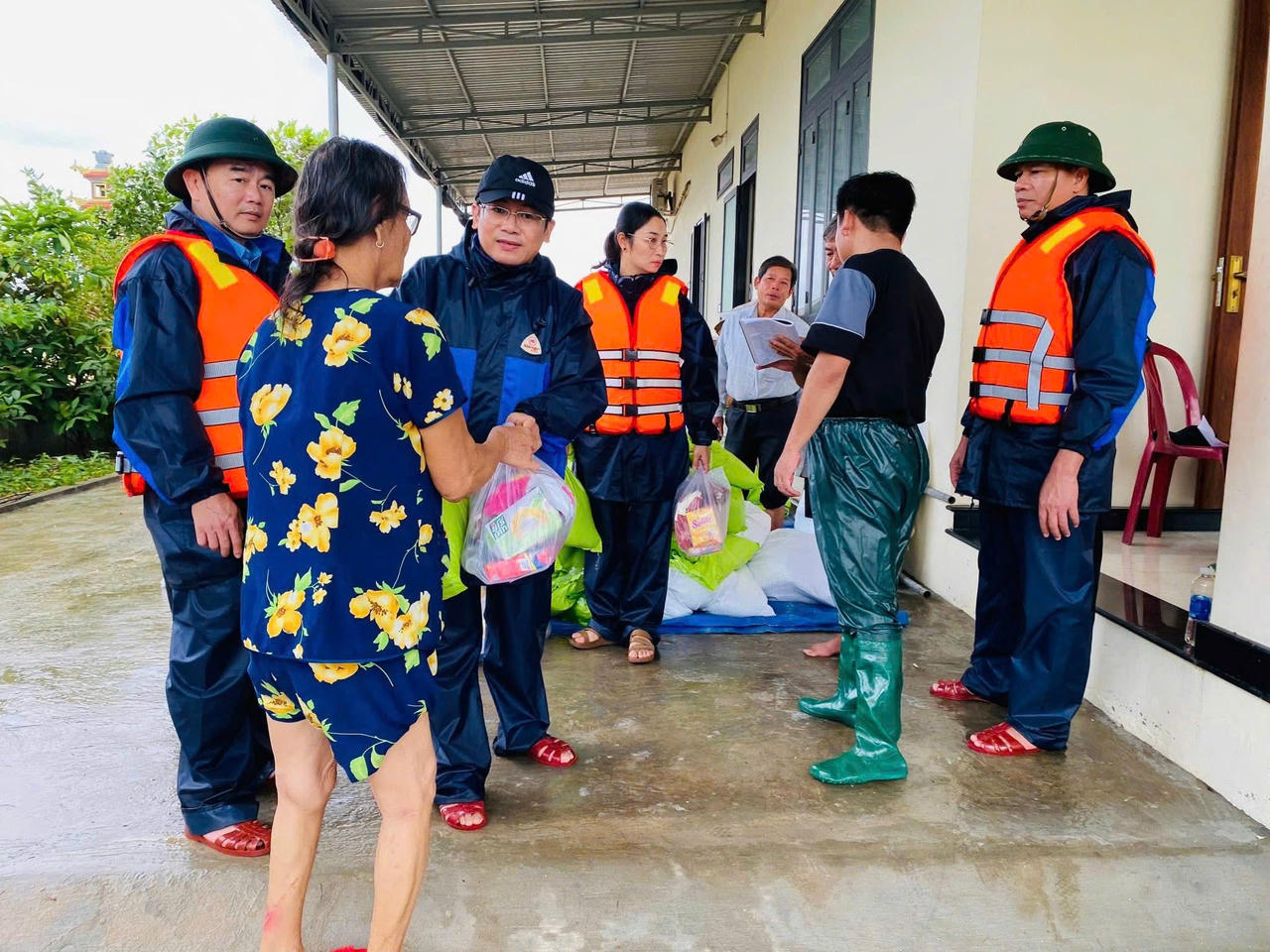 Các Phó Chủ tịch UBND phường Nguyễn Cửu Ngọc và Nguyễn Quang Bình hỗ&nbsp;trợ nhu yếu phẩm thiết yếu cho người dân vùng ngập lụt.