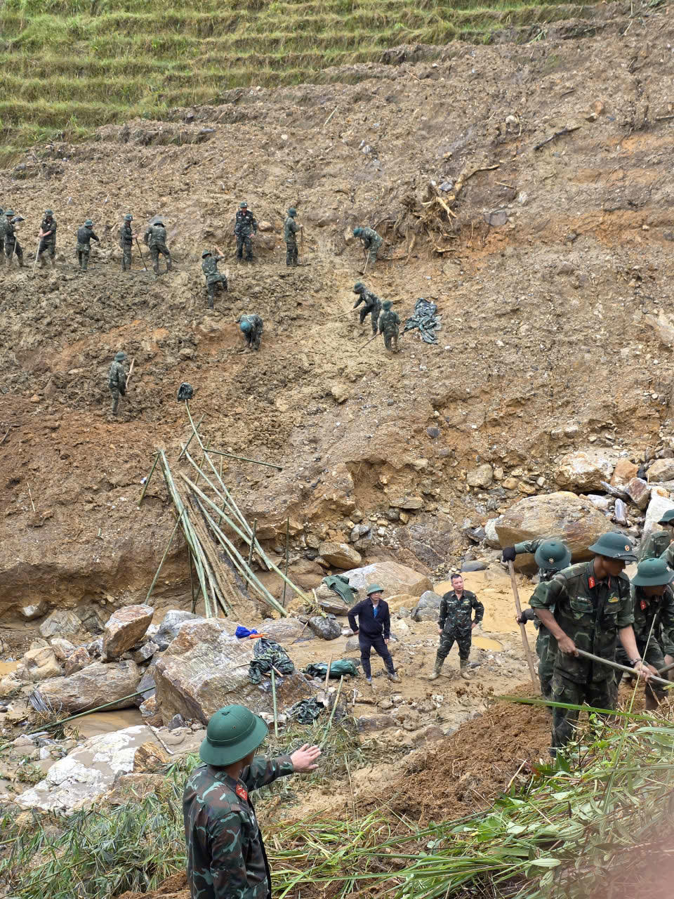 Lực lượng bộ đội nỗ lực san gạt đất đá tại khu vực sạt lở lớn ở xã Ngọc Linh để sớm thông tuyến đường cho người dân.