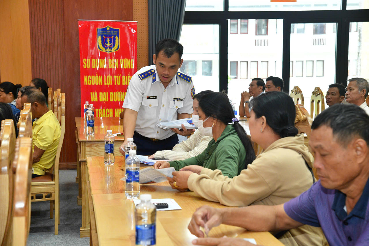 Cán bộ Bộ Tư lệnh Vùng Cảnh sát biển 4 phát tờ rơi tuyên truyền cho bà con ngư dân.