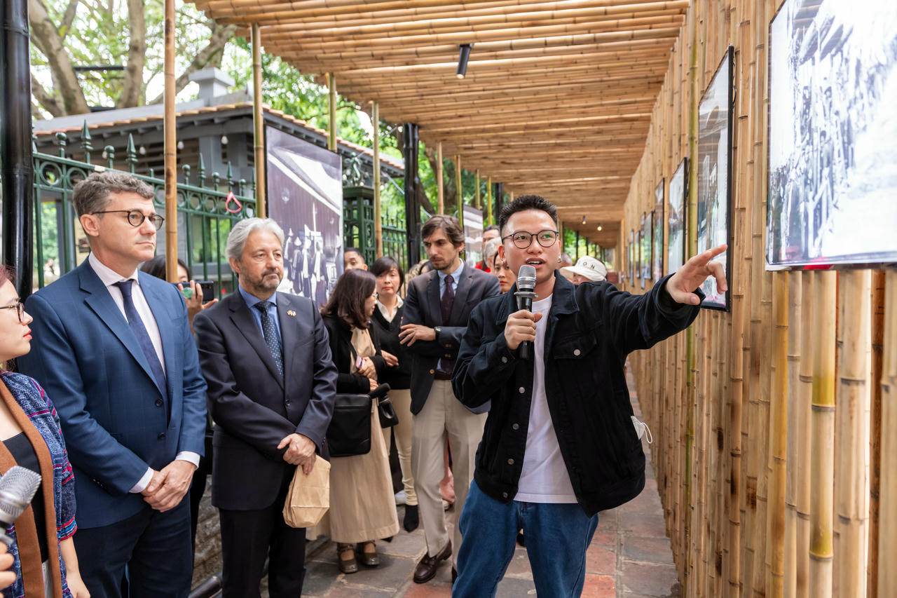 Ông Jonathan Wallace Baker (áo vest xanh bên trái), Trưởng đại diện Văn phòng UNESCO tại Hà Nội và ông&nbsp;Eric Soulier (áo Vest đen ở giữa), Tham tán văn hóa của Đại sứ quán Pháp tại Việt Nam đang xem và nghe thuyết trình về những bức ảnh về "Khoa Thi Hương cuối thế kỷ 19”