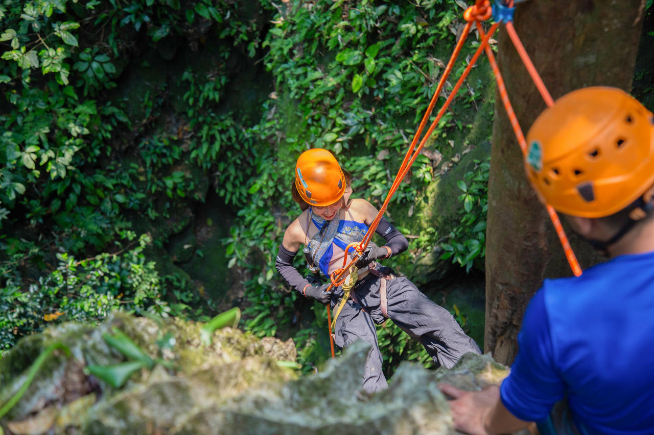 Du khách được trang bị các thiết bị an toàn cần thiết, sẵn sàng trải nghiệm đu dây 25m xuống hố sụt hang Thung. Ảnh: Jungle Boss Tours