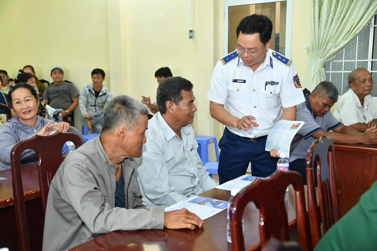 Cán bộ BTL Vùng Cảnh sát biển 4 tiến hành phát tờ rơi tuyên truyền, hướng dẫn bà con ngư dân quét mã QR tra cứu các quy định pháp luật về chống khai thác IUU tại các “phiên tòa giả định”.