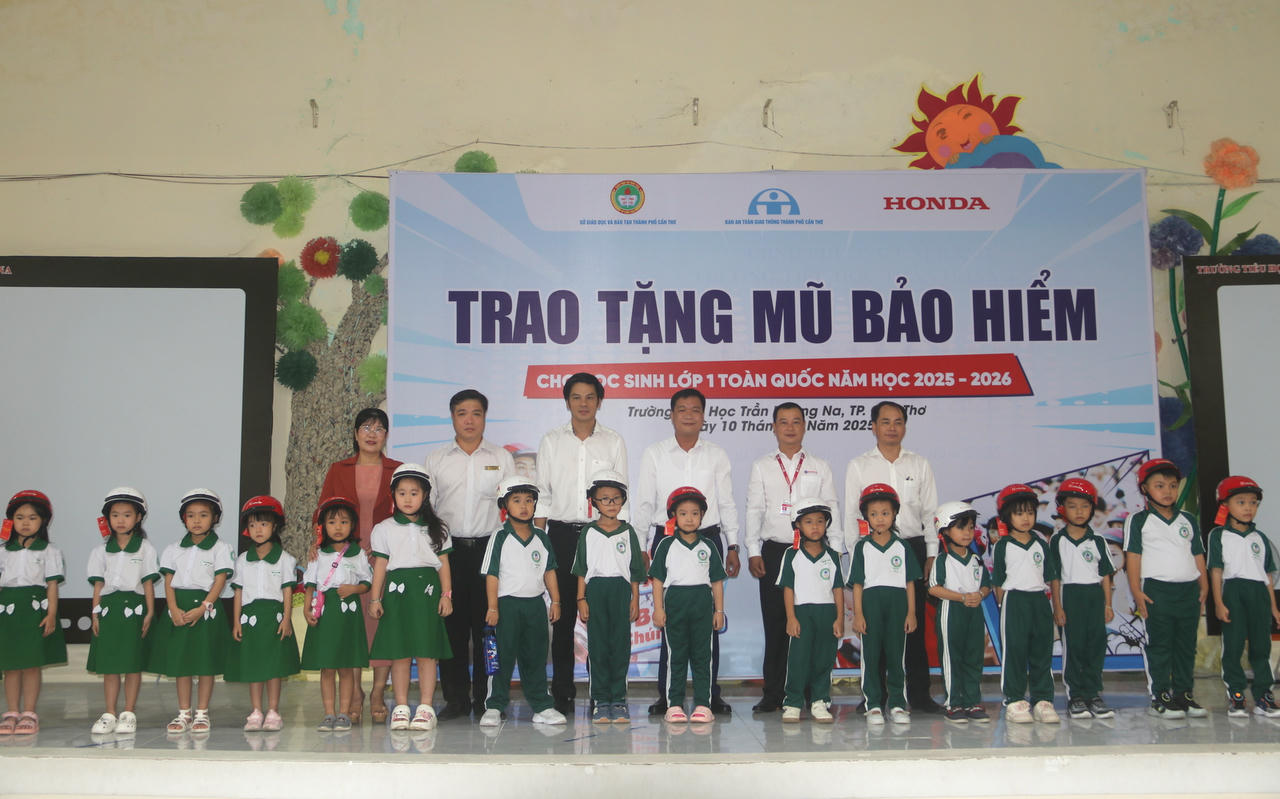 Các lãnh đạo trao tặng mũ bảo hiểm cho các em học sinh