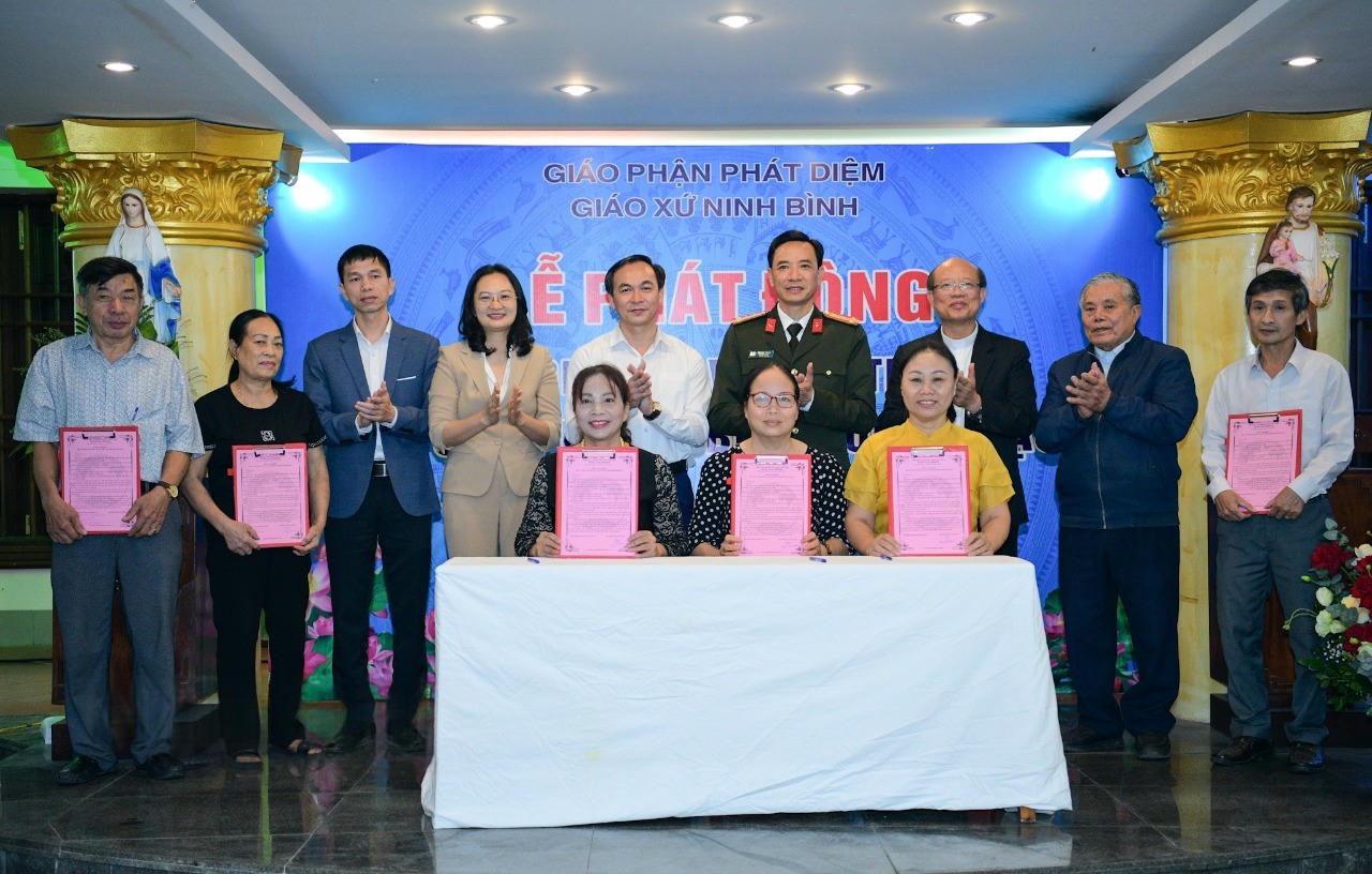 Đại diện các hộ gia đình ký cam kết với Giáo xứ Ninh Bình về bảo vệ môi trường, ứng phó với biến đổi khí hậu. (Ảnh: Xuân Thu)