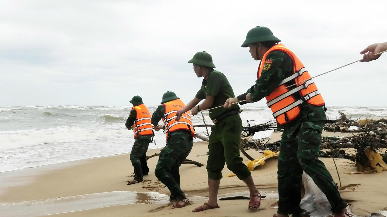 Các lực lượng phối hợp đưa dây cứu kéo thuyền viên vào bờ.
