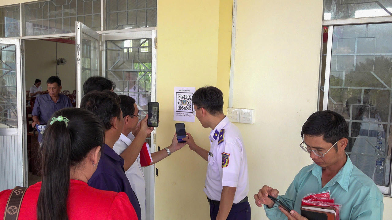 Cán bộ Hải đoàn 42 cấp phát mã QR "Sổ tay điện tử IUU" dán tại các cảng cá, bến tàu và trên các phương tiện khai thác.