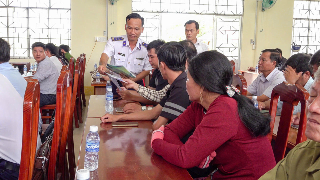 Cán bộ Cảnh sát biển phát tờ rơi tuyên truyền cho các ngư dân.