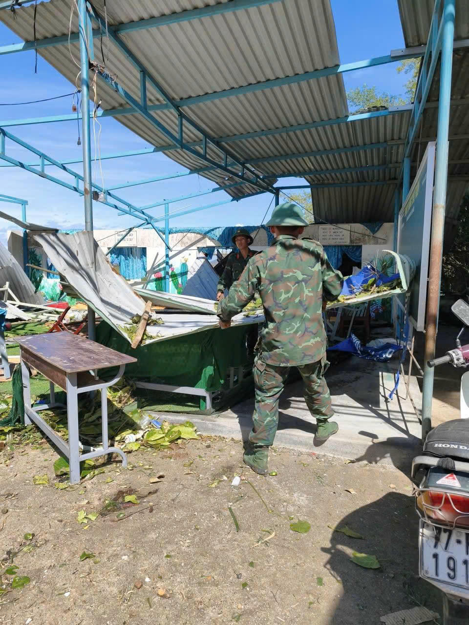 Chiến sĩ Sư đoàn 31 dọn dẹp tại một căn nhà bị sập hoàn toàn, khung cảnh tan hoang sau bão.