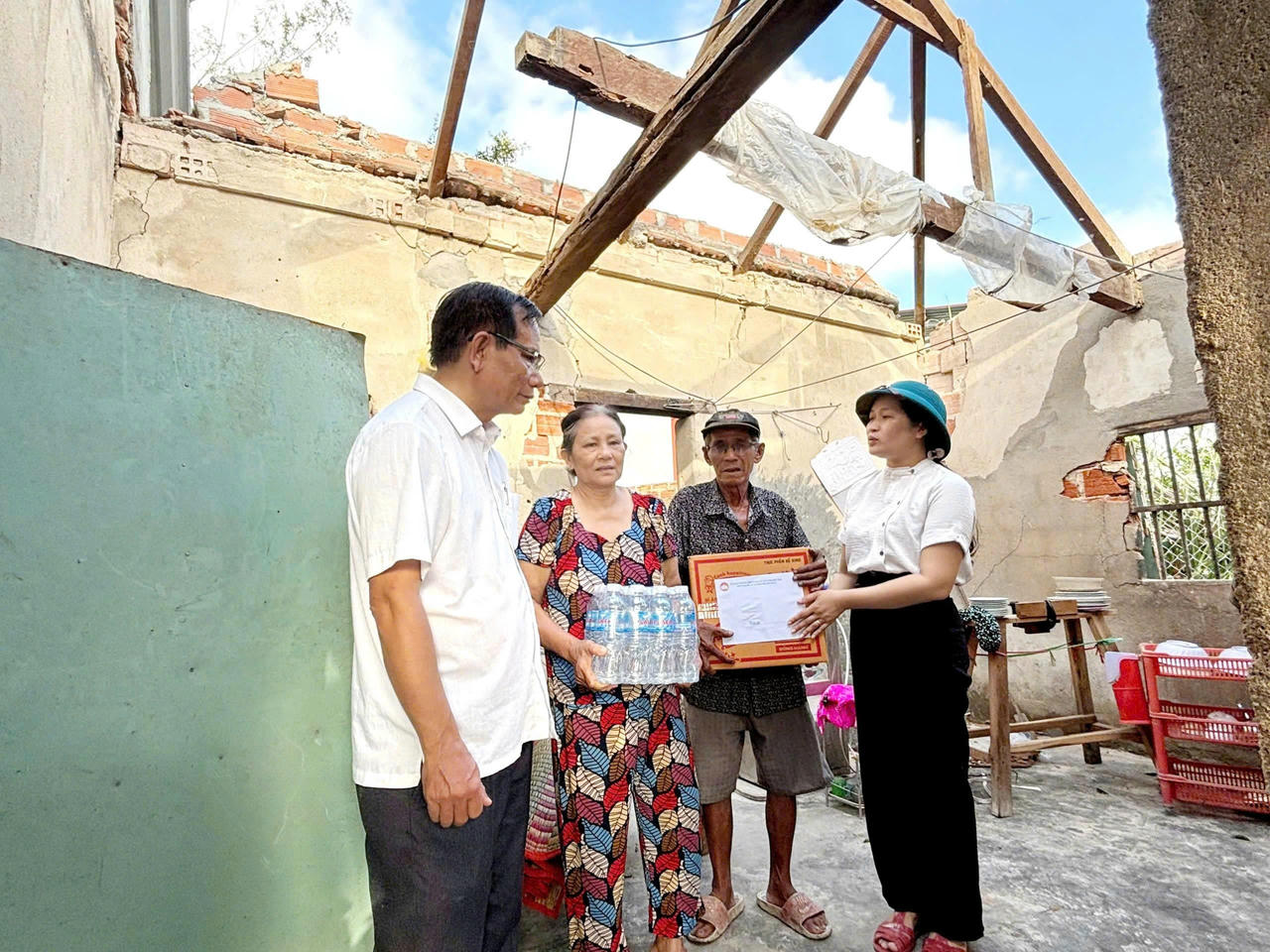 Lãnh đạo xã và các tổ chức đoàn thể trao hỗ trợ cho người dân bị ảnh hưởng bão lũ.