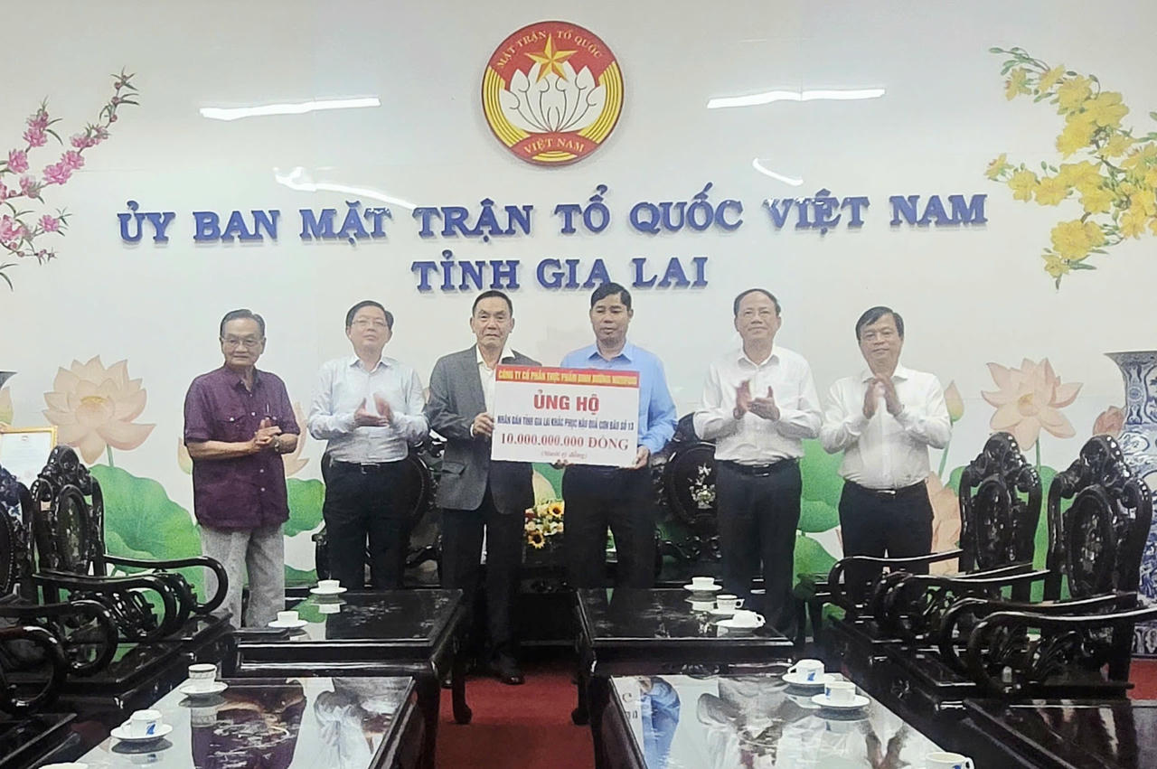 Phó Thủ tướng Hồ Quốc Dũng cùng đại diện Công ty Nutifood trao bảng tượng trưng 10 tỷ đồng ủng hộ.