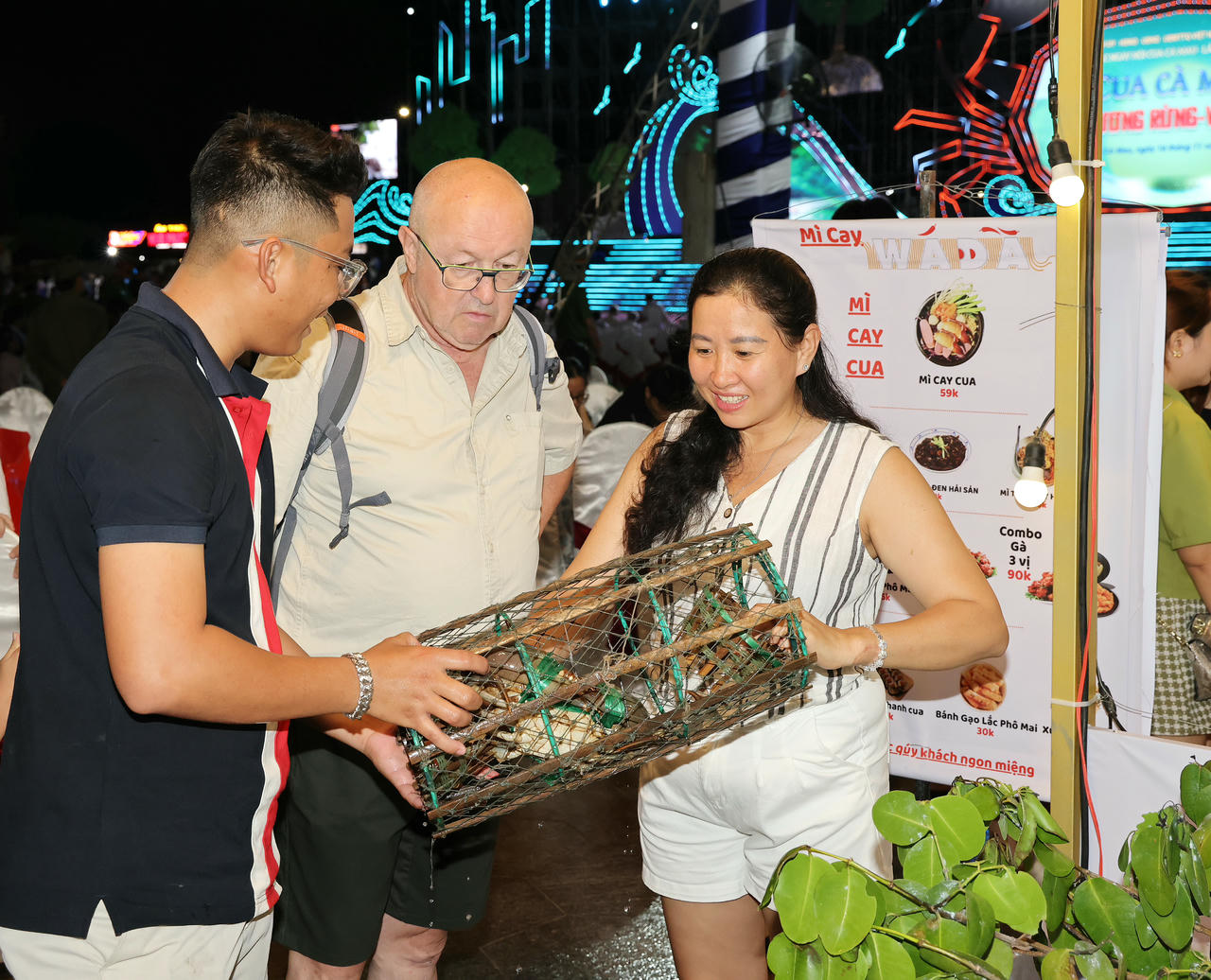 Du khách quốc tế tham quan khu ẩm thực và trải nghiệm các món ăn đặc sắc từ con cua Cà Mau. (Ảnh: Phạm Trung)