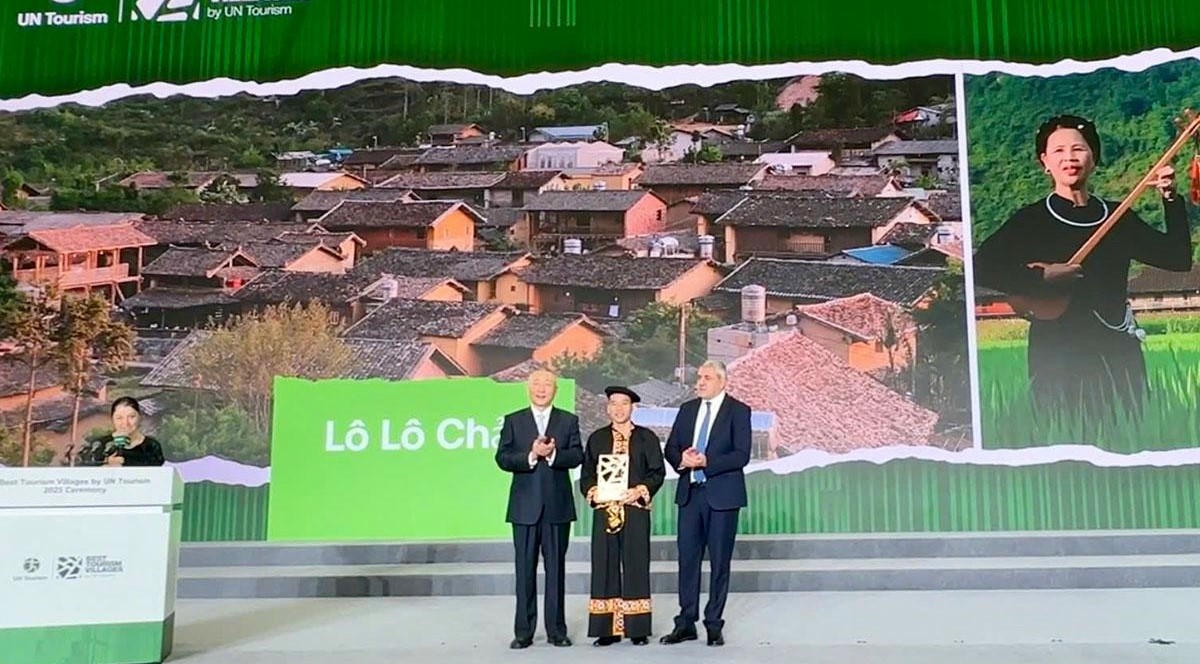 Bí thư Đảng ủy xã Lũng Cú (ở giữa) nhận&nbsp;“Làng du lịch tốt nhất thế giới 2025” từ&nbsp;Tổ chức Du lịch Liên hợp quốc. Ảnh: BTC.