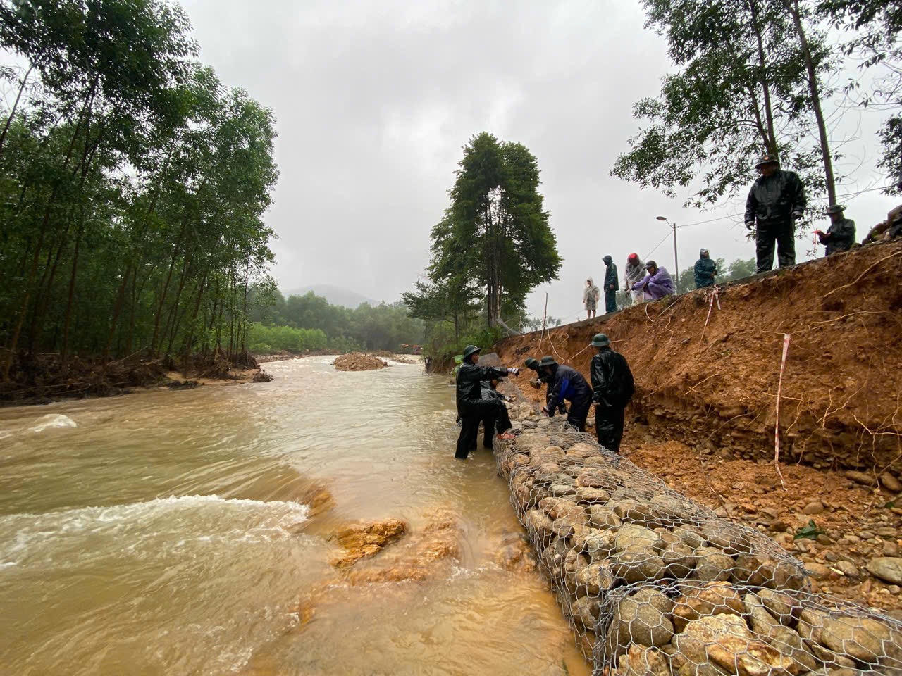 Cán bộ, chiến sĩ và lực lượng dân quân tham gia khắc phục sạt lỡ tại xã Hưng Lộc.