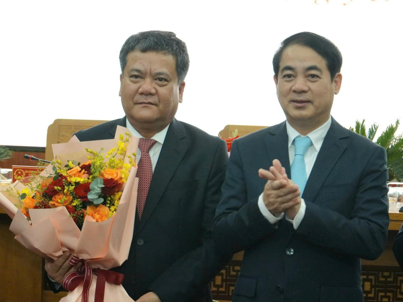 Bí thư Tỉnh ủy Nghiêm Xuân Thành (phải) tặng hoa chúc mừng tân Chủ tịch UBND tỉnh Trần Phong.