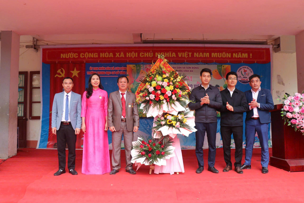Ông Lục Xuân An và các đại biểu tặng hoa chúc mừng tập thể Trường THCS Vĩnh An.