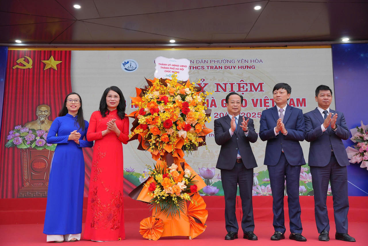 Lãnh đạo Thành ủy - HĐND - UBND thành phố Hà Nội trao lẵng hoa chúc mừng.