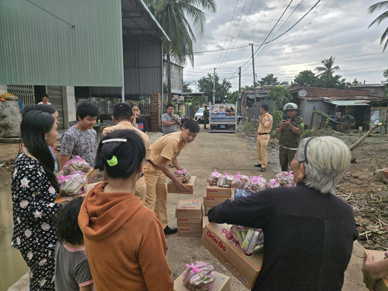 Lực lượng Công an vận chuyển mì tôm và nước uống xuống từng hộ dân bị ảnh hưởng nặng bởi mưa lũ.