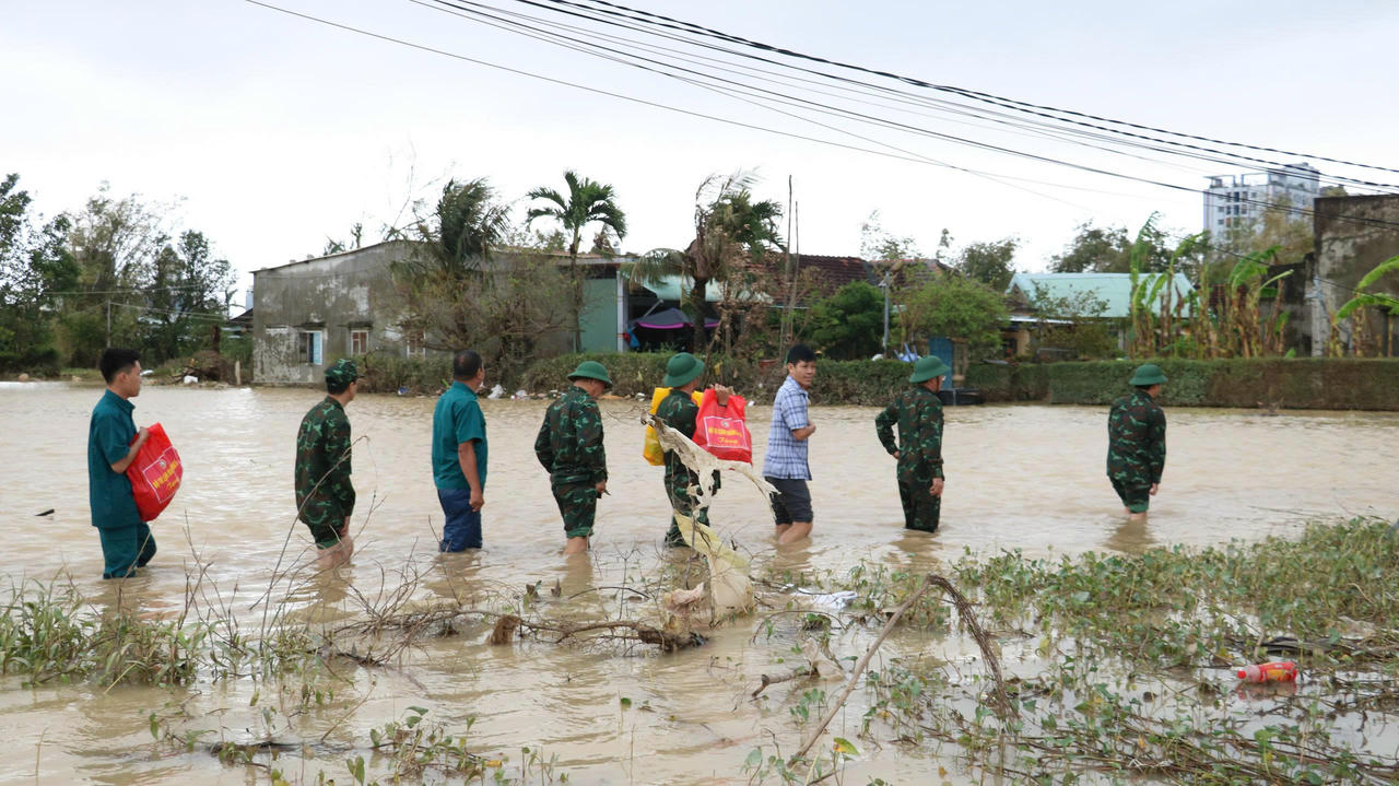 Đoàn công tác Tổng cục Chính trị QĐND Việt Nam lội qua dòng nước lũ đến tận nơi chia sẻ với những tổn thất của bà con vùng lụt.