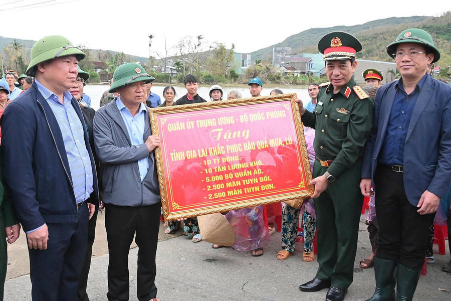 Đại tướng Phan Văn Giang trao bảng tượng trưng gửi tặng phần hỗ trợ từ Quân ủy Trung ương, Bộ Quốc Phòng đến đồng bào Gia Lai. Ảnh: Báo Gia Lai.