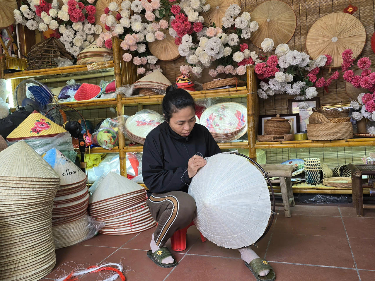 Những chiếc nón tròn trịa dưới bàn tay kỳ cựu của chị Lưu Thị Huệ. (Ảnh: Xuân Lai)