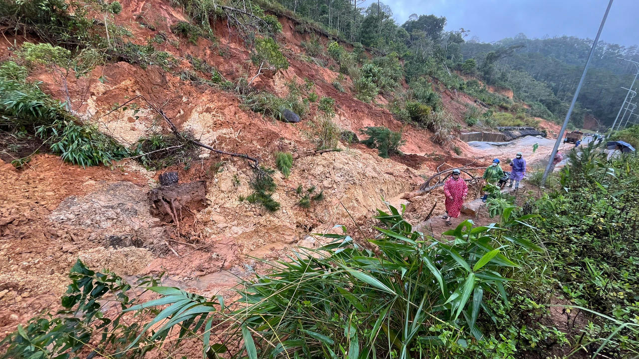 Lực lượng chức năng tiếp cận hiện trường sạt lở để khắc phục, mở lối tạm cho phương tiện lưu thông.