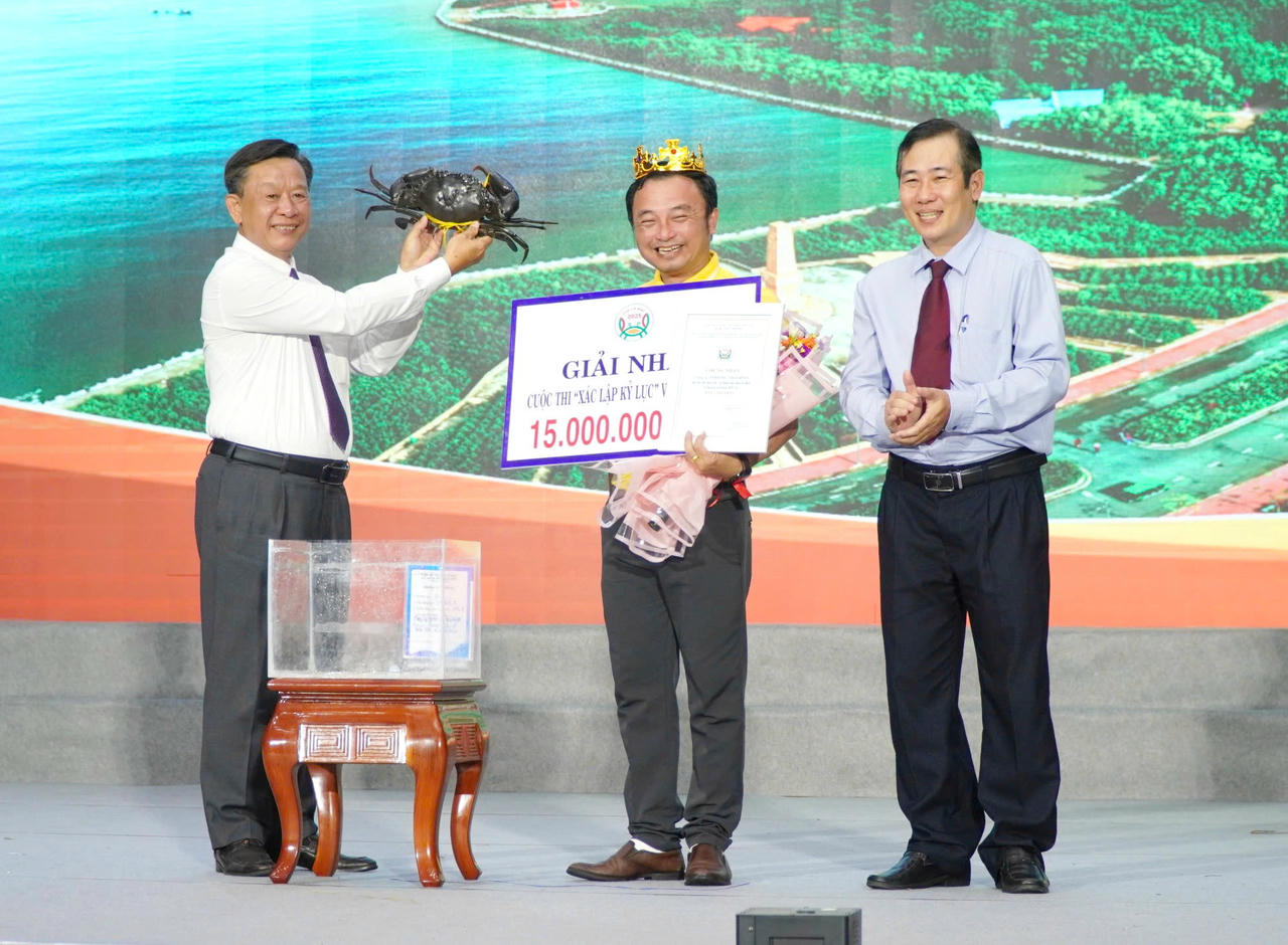 Ông Hồ Trung Việt – Ủy viên Ban Thường vụ Tỉnh ủy, Trưởng Ban Tuyên giáo và Dân vận Tỉnh ủy Cà Mau (bên trái) trao chứng nhận cho đại diện Công ty TNHH Dư Thái Bình (ấp Kinh Tắc, xã Năm Căn, tỉnh Cà Mau), đơn vị có con cua nặng 1.889,2 gram, đạt giải Nhất cuộc thi cua có trọng lượng lớn nhất.