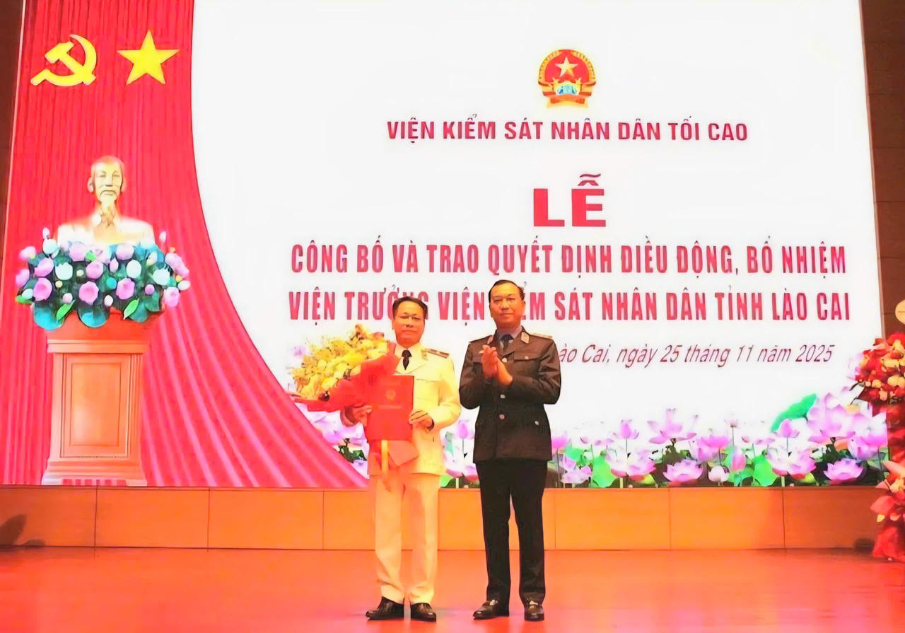 Ông Hồ Đức Anh, Phó Bí thư Thường trực Đảng ủy, Phó Viện trưởng VKSND tối cao trao quyết định và tặng hoa chúc mừng ông Đỗ Đình Chữ.