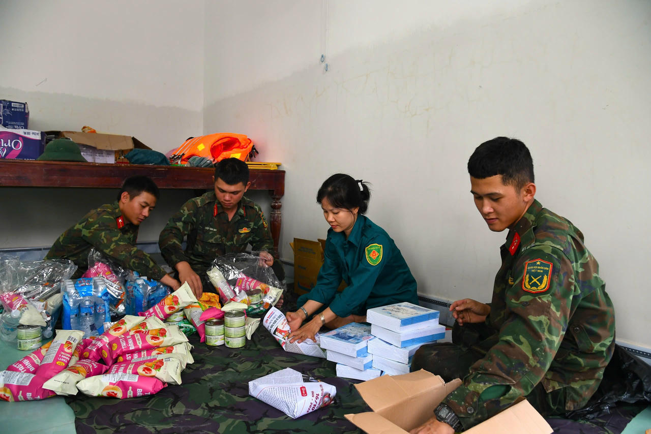Chiến sĩ Sư đoàn 2 cùng dân quân xã Tuy An Đông, người gói bánh kẹo, người xếp vở, bút…