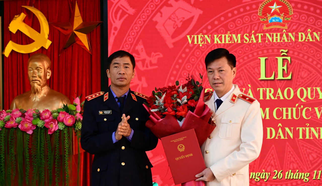 Phó Viện trưởng Viện KSND tối cao trao quyết định, tặng hoa chúc mừng ông Lý Văn Huấn. (Ảnh: Minh Hoa)