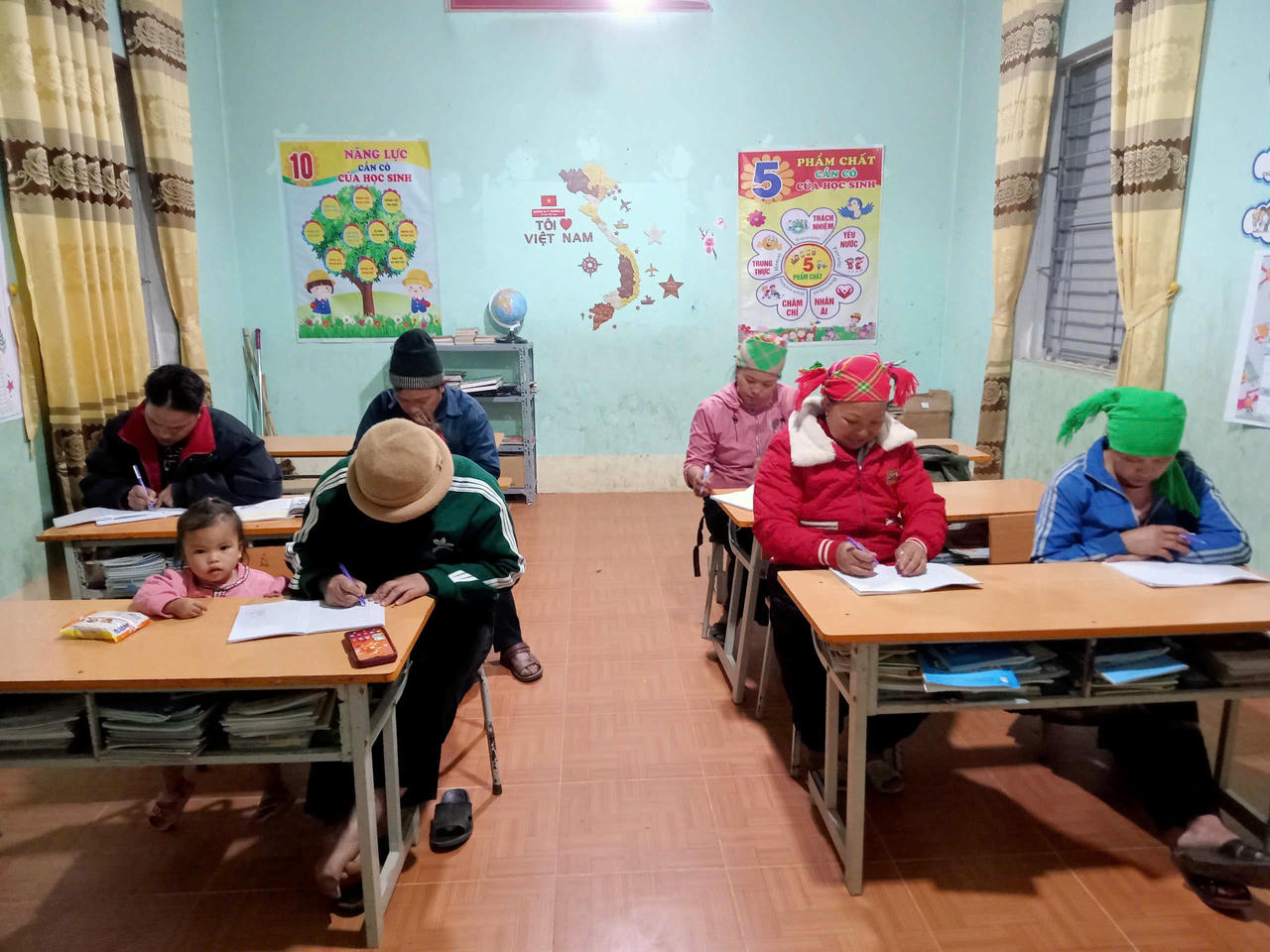 Bàn tay chai sạn cầm bút viết nên ước mơ học chữ giữa mùa đông lạnh giá.