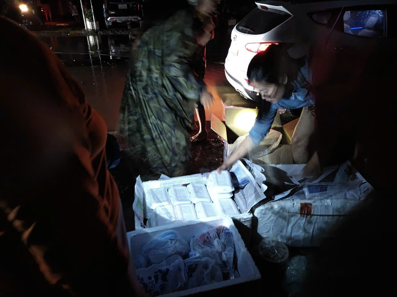 Những hộp cơm nóng được PV Báo PLVN nấu và trao cho bà con khu vực ngập trong đêm tối 20/11.