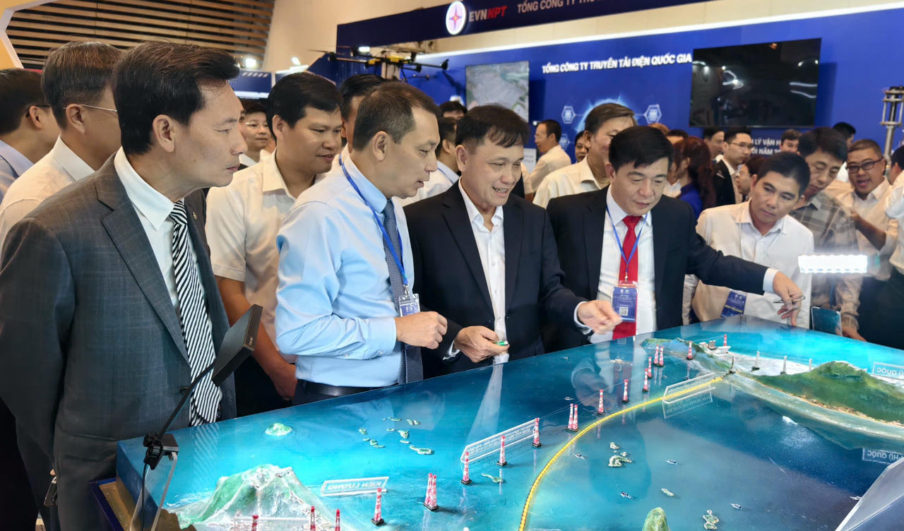 Ông Đặng Hoàng An - Chủ tịch Hội đồng Thành viên EVN (thứ 2 từ trái qua) và các đại biểu tham quan gian hàng hội nghị.