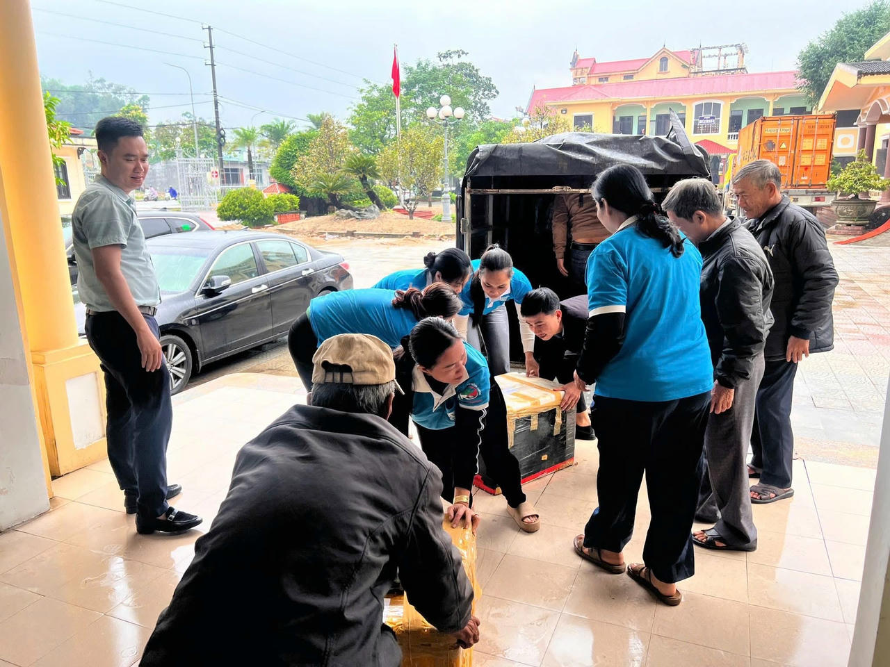 Từng thùng nhu yếu phẩm được chuyền tay nhau lên xe để kịp thời chuyển vào tâm lũ.