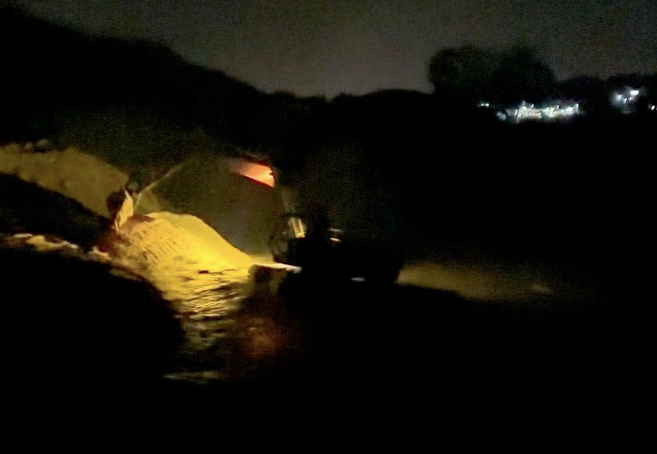 Xe múc đang múc cát giữa đêm tại suối giáp đường Păng Tiêng Phi Tô.