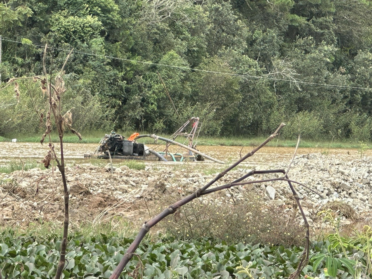 Máy hút cát tắt máy "nằm chờ" trên suối.